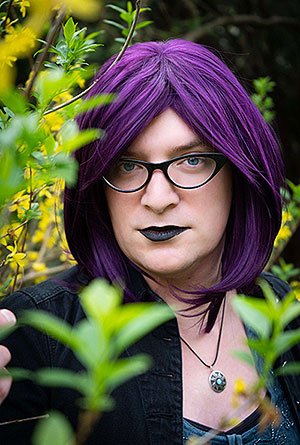 Author Emily Wynne standing in a wooded area.